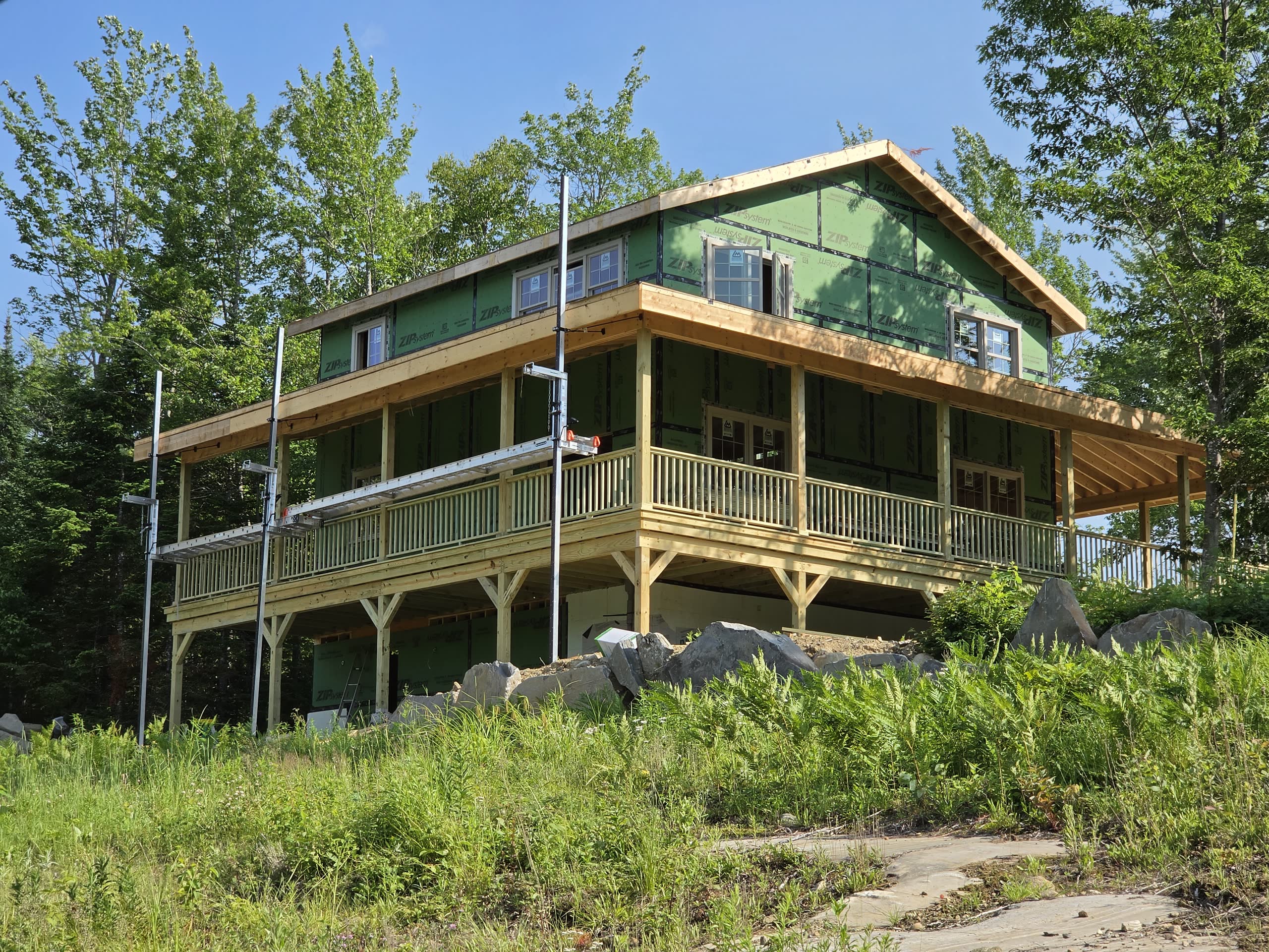 Custom home with wraparound porch under construction by Winter Construction in Phillips, Maine